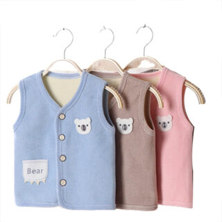 Trois gilets - bleu, rose et beige suspendus à des ceintres