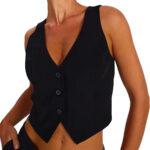 On voit une femme qui porte une gilet de costume noir court qui laisse voir son nombril. Elle ne porte rien en dessous. Elle est plutôt bronzée.