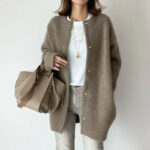Gilet mi long camel à pression porté par une femme habillé d'un pantalon gris et un tee shirt blanc