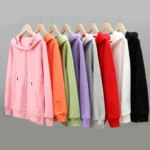 Photo de huit gilets à capuche de différentes couleurs sur cintre