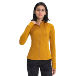 Photo d'une femme debout portant un pantalon noir et un gilet zippé à capuche jaune le tout sur fond blanc