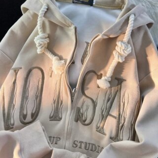 Photo d'un gilet à capuche zippé beige avec grosses lettres brodées et gros cordon de serrage de la capuche