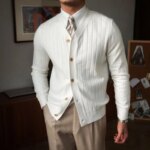 Gilet blanc en tricot à manches longues porté par un homme qui porte un pantalon beige.