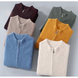 Photo de plusieurs gilets en cachemire zippés à col rond pliés, de différentes couleurs, superposés, sur fond gris.