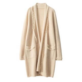 Sur fond blanc, on voit un long gilet beige pour femme avec deux poches avec des franges sur le devant.