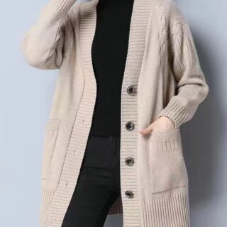 Gilet mi-long beige en tricot porté par une femme habillé en noir