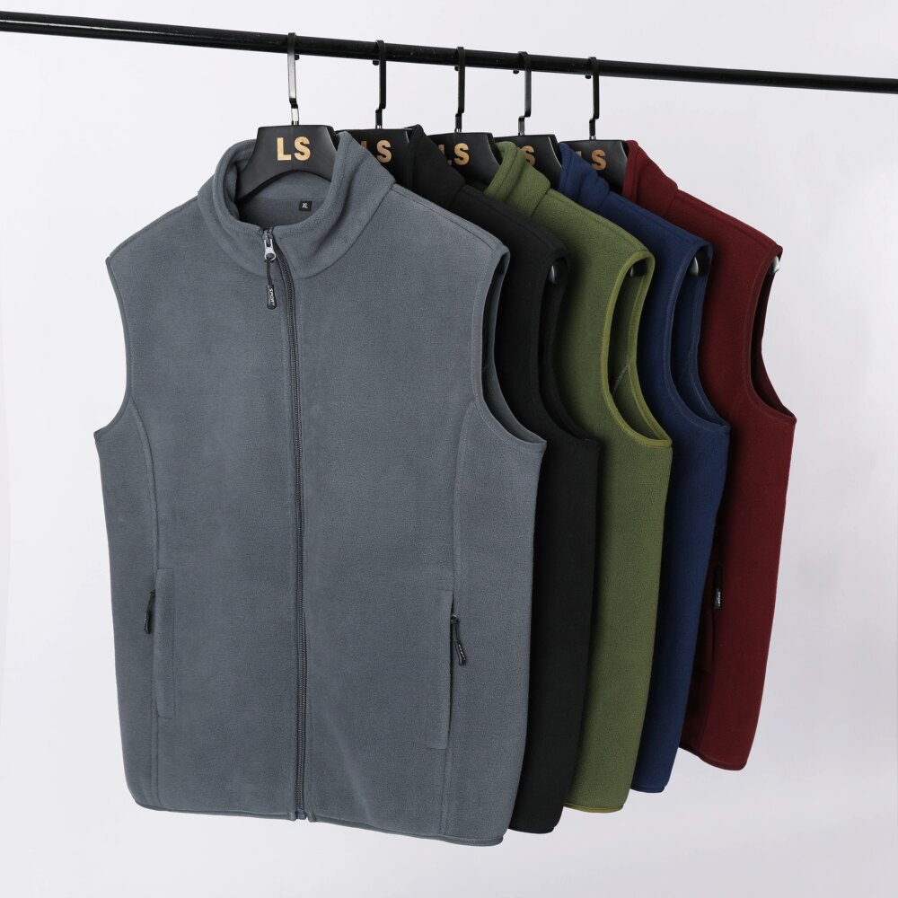 Photo de plusieurs gilet polaire sans manches suspendu à des cintres sur un portant, sur fond gris