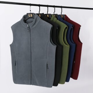 Photo de plusieurs gilet polaire sans manches suspendu à des cintres sur un portant, sur fond gris