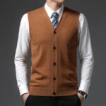 Homme portant un gilet sans manche marron et une chemise sur fond gris.