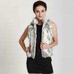 Photo d'une femme debout portant un gilet zippé en fourrure de lapin gris sur robe courte noire