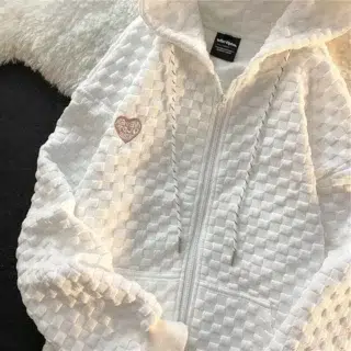 Photo d'un gilet sweat blanc fermé à capuche et tissu à imprimé en relief posé manches légèrement repliées