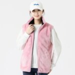 On voit une femme qui porte une gilet chauffant en matière douce et rose. Elle a une casquette blanche. Le gilet est sans manches.