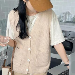 on voit une femme brune portant un gilet ample sans manches de couleur beige le gilet est rétro pour femme