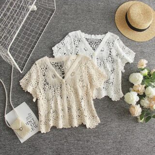 on voit sur un sol gris deux gilet aéré court en crochet pour femme un beige et un blanc