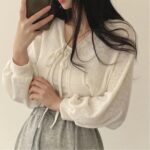 on voit une femme brune portant un gilet court et fin à manches bouffantes pour femme il est blanc