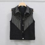 on voit sur un fond gris clair un gilet court noir à franges pour femme