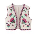 on voit sur un fond blanc un gilet court sans manches avec des fleurs roses brodés dessus pour femme