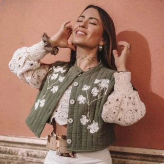 une femme avec un gilet vintage sans manches fleuri vert et blanc