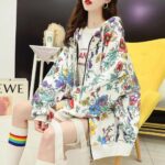 on voit une jeune femme portant un gilet zippé ample de couleur blanc à motifs floraux pour femme