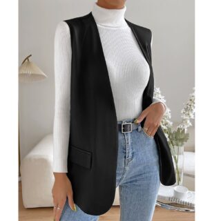 Une femme portant un gilet manches courtes noir style blazer avec un pull col roulé blanc