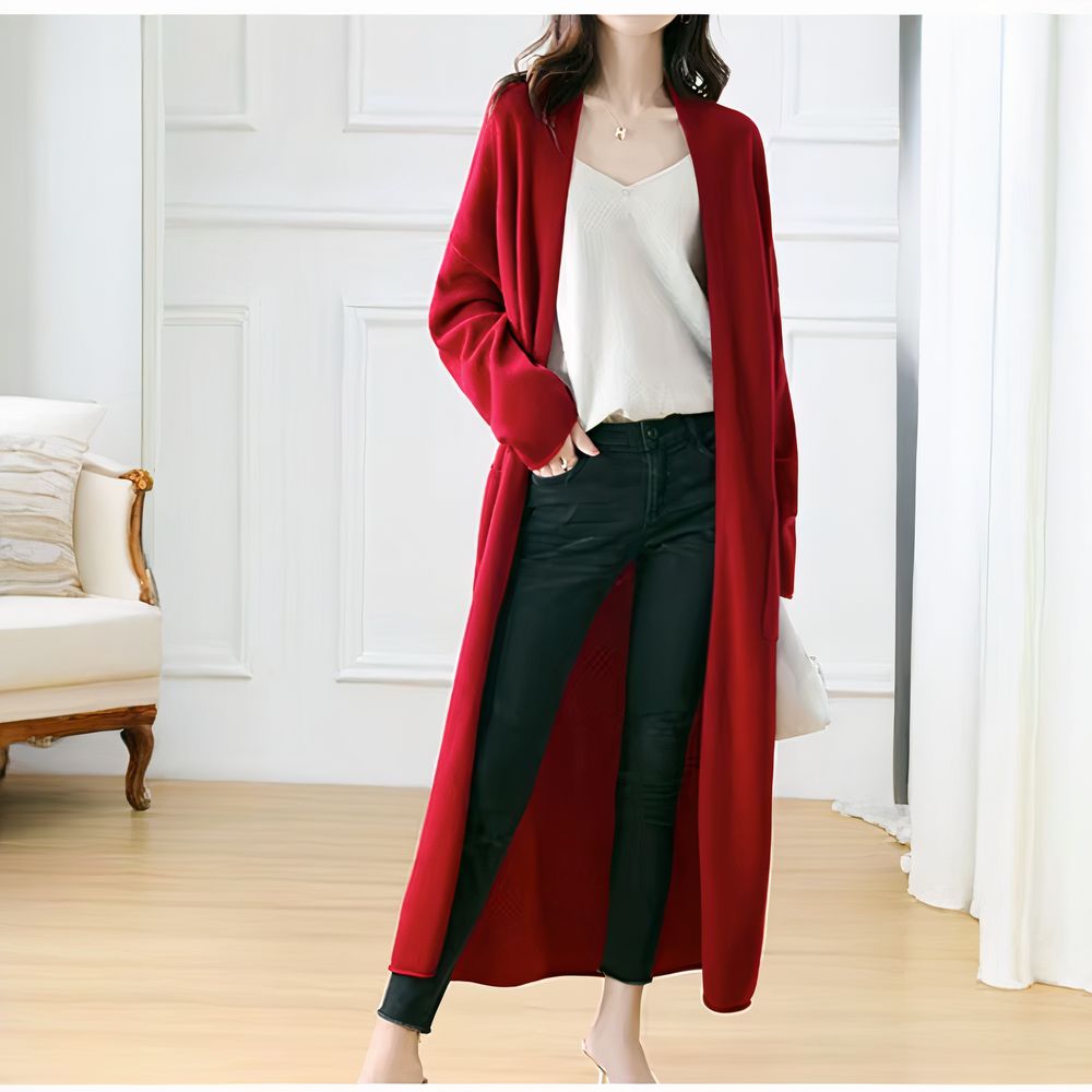 Femme portant un gilet long rouge en laine, coupe fluide et élégante.